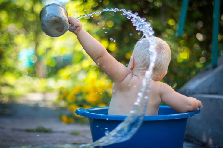 toddler in bucket splashing water