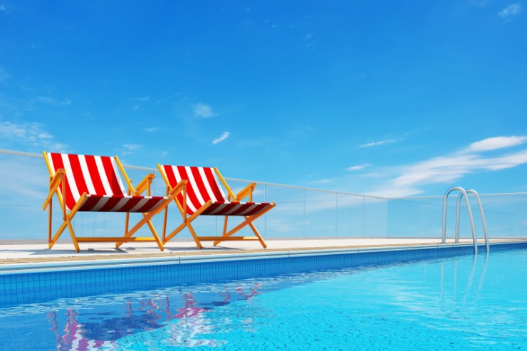 Resort style pool with two deck chairs