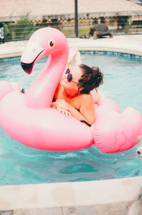 woman on a pool flamingo float