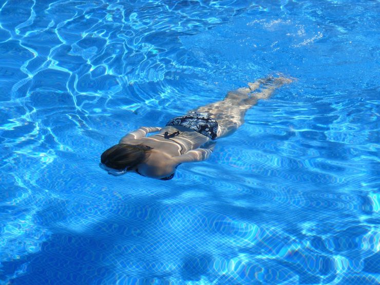 woman swimming underwater in a pool