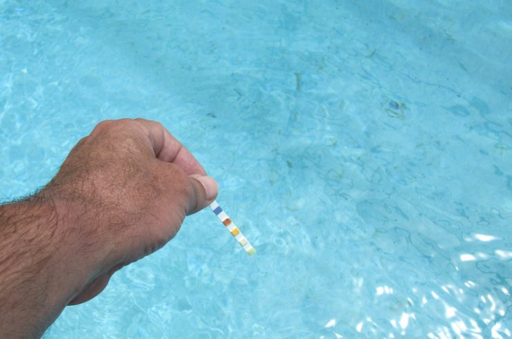 man using test strips to test cyanuric acid level in pool


