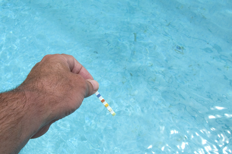 man-testing-swimming-pool-water