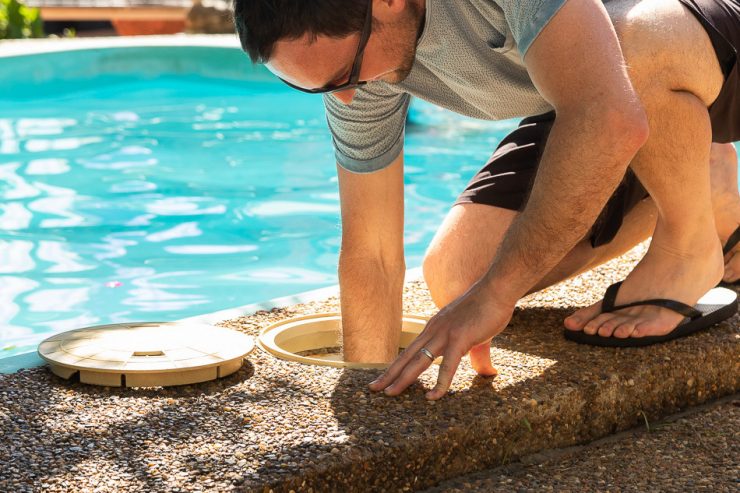 man pouring the stabilizer in the skimmer box