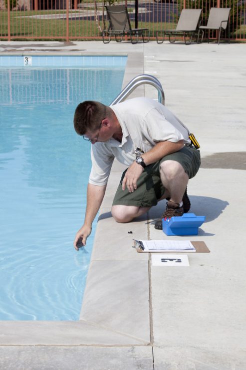 a man testing swimming pool water