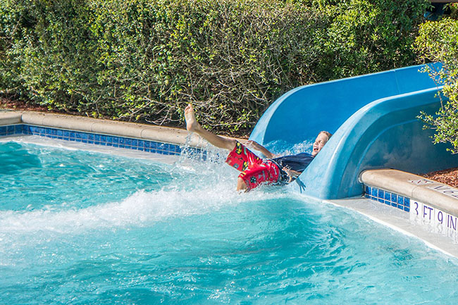 Boy enjoying the pool slide - Best Above Ground Pool Slides