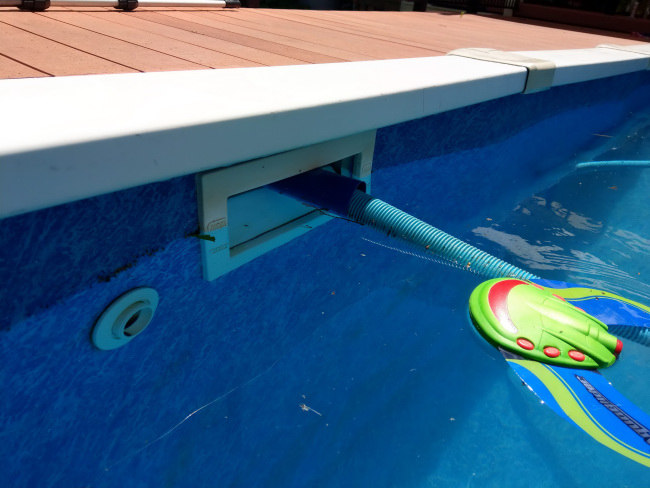 Above ground pool skimmer opening with pool cleaner hose.