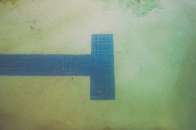 Dirty, cloudy, and murky swimming pool with algae