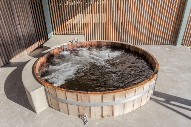 Wooden outdoor hot tub filled with water