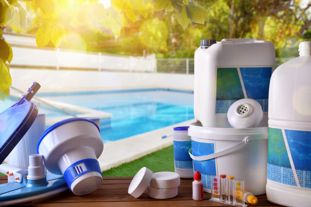 Pool chlorine and other cleaning equipment beside the pool