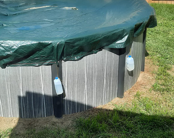 Water bottles holding and keeping the pool cover in place.