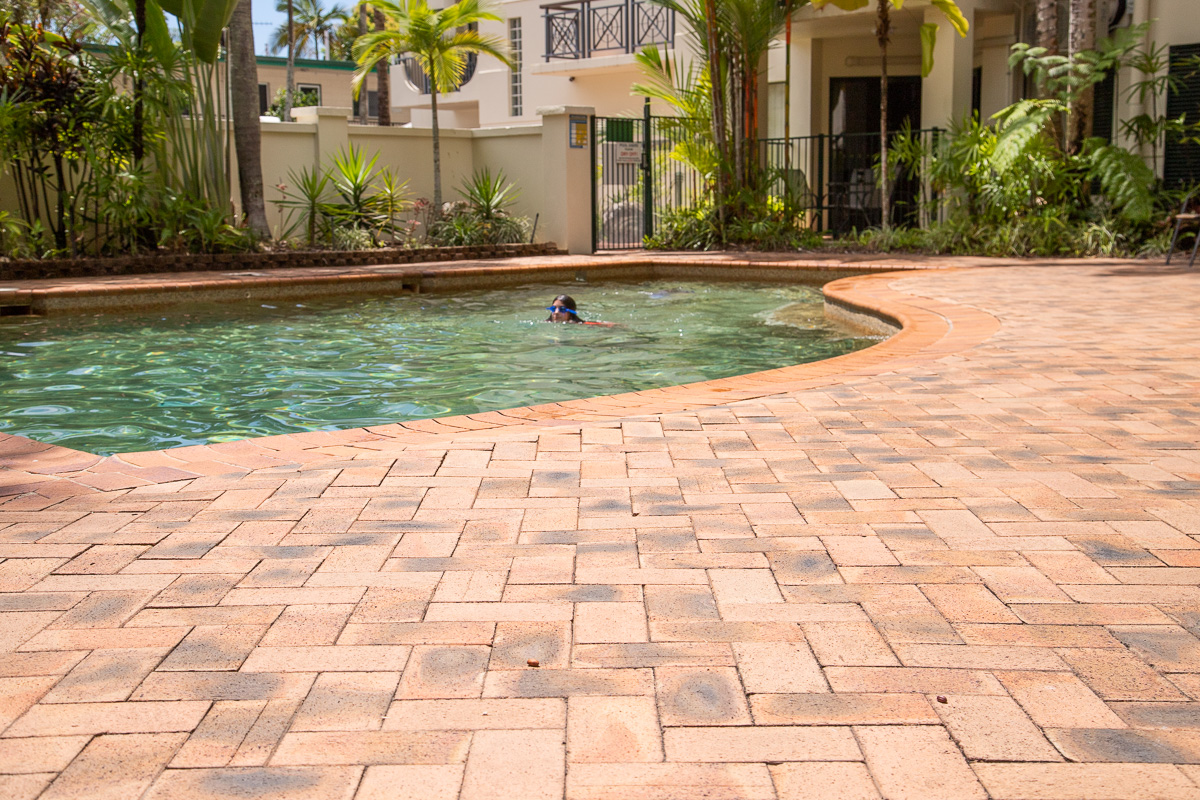 Brick herringbone pattern pool deck paving.