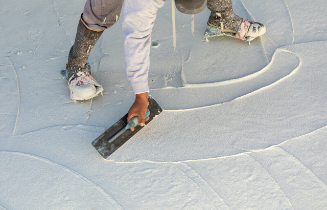 Man smoothing wet pool plaster.