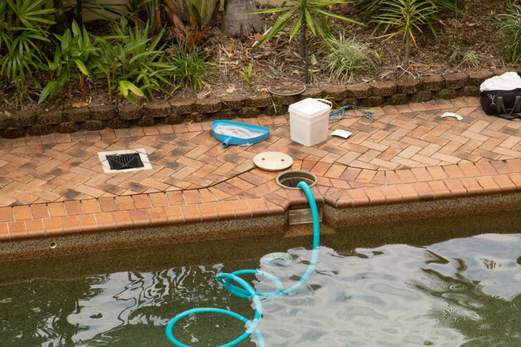 Pool vacuum hose connected to skimmer.