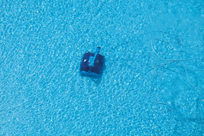 Robotic pool cleaner vacuum cleaning a pool underwater.