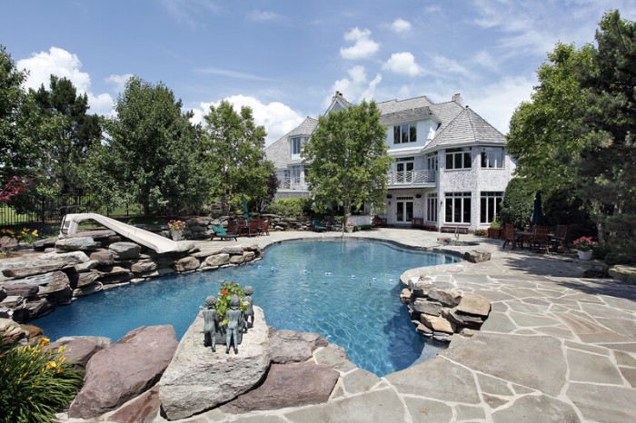 rear view of luxury home with swimming pool